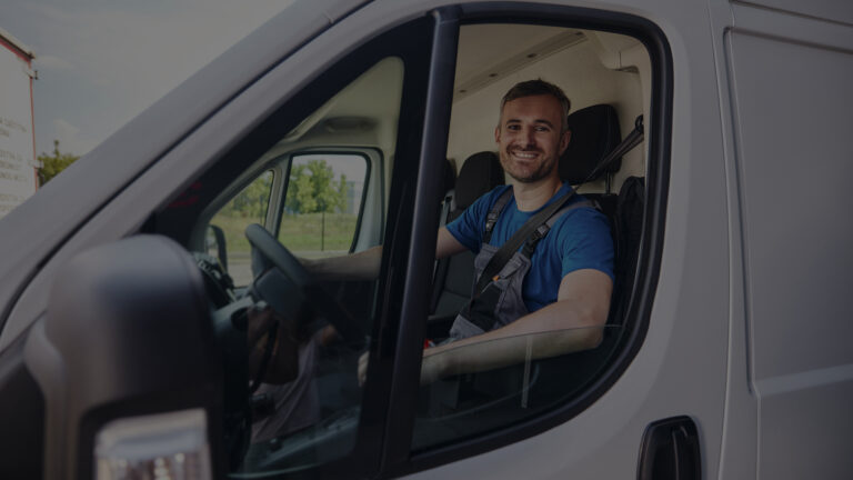 Happy delivery man driving a van